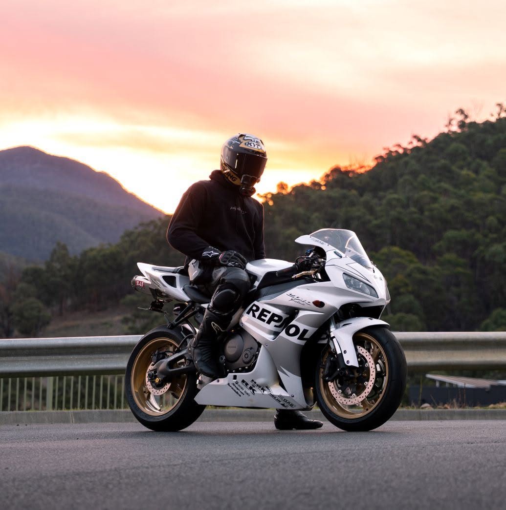 Rider on a Repsol Honda watching the sun set over Tasmania